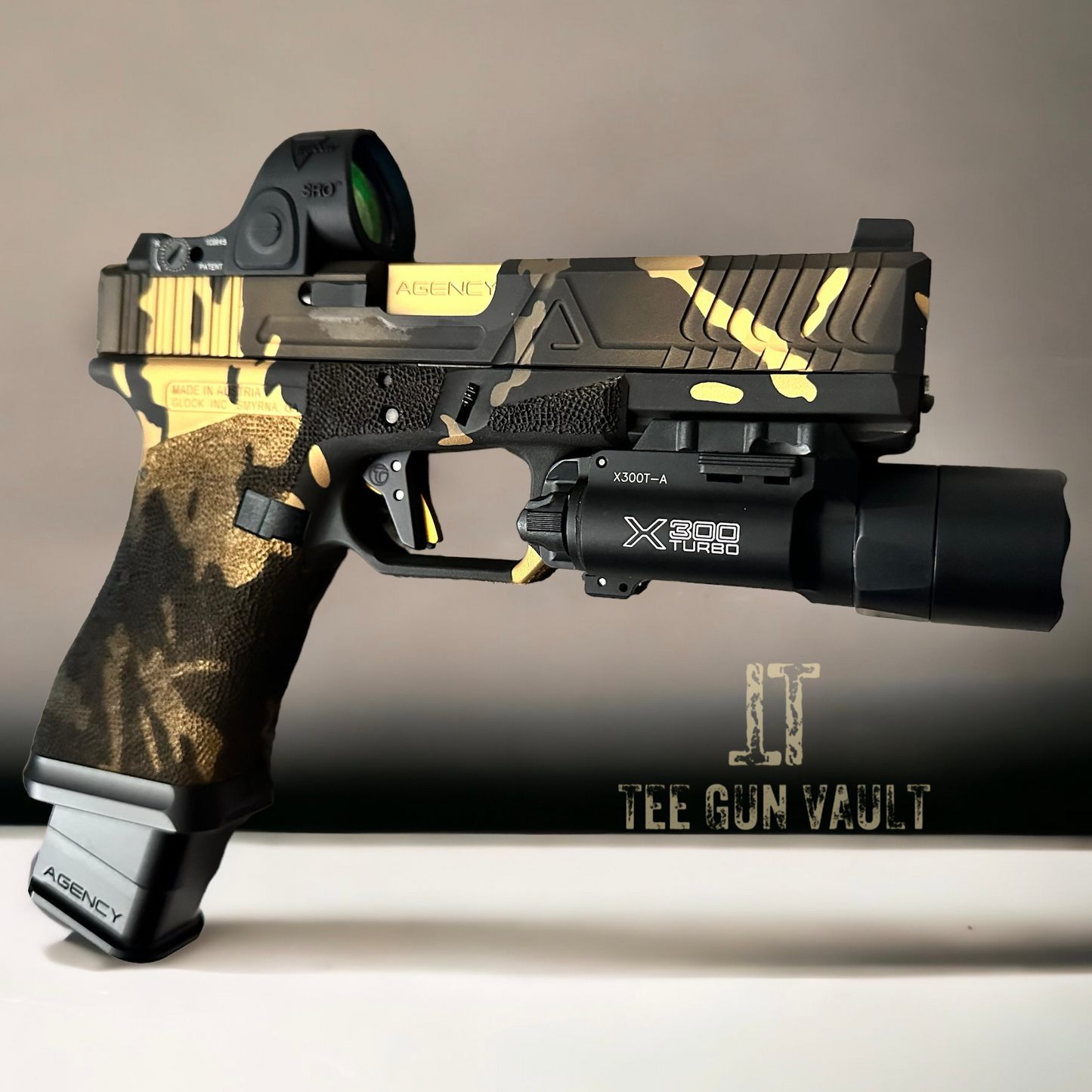 AGENCY ARMS GLOCK 17 MULTI CAM BLACK & GOLD WITH TIMNEY (PRE OWNED)